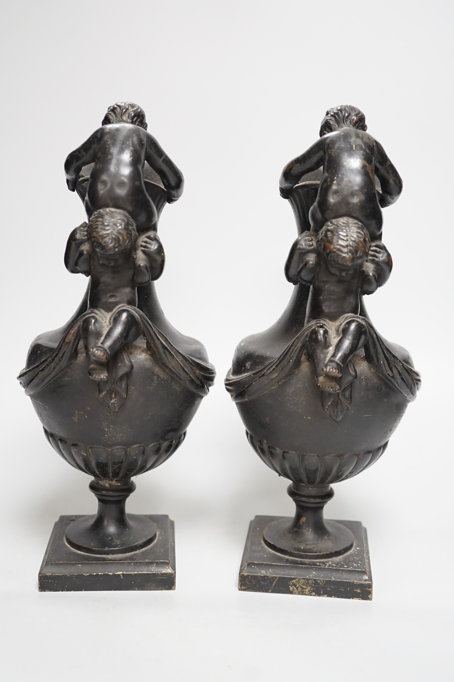 A pair of classical revival bronze urn side ornaments with cast rams head bodies. 32cm tall